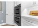 Close-up of double stainless steel oven with custom white cabinets and countertop at 3500 Ballastone Dr, Land O Lakes, FL 34638