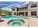 Backyard pool and spa with a screened enclosure and a covered patio area at 3500 Ballastone Dr, Land O Lakes, FL 34638