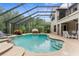 Resort-style pool area with a covered patio, seating, and lush landscaping, and a view of the backyard at 3500 Ballastone Dr, Land O Lakes, FL 34638