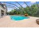 Beautiful screened-in pool area with spa, lush landscaping and outdoor seating, ideal for entertaining guests at 3500 Ballastone Dr, Land O Lakes, FL 34638