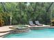 Heated pool and spa features a screened enclosure and is surrounded by lush landscaping at 3500 Ballastone Dr, Land O Lakes, FL 34638