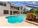 Backyard pool and patio area featuring a screened enclosure and lush landscaping at 3500 Ballastone Dr, Land O Lakes, FL 34638