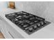 Close-up of a modern stainless steel gas stovetop in a white kitchen at 3500 Ballastone Dr, Land O Lakes, FL 34638