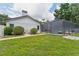 A spacious, green backyard featuring a screened-in pool and a glimpse of the home's exterior at 3509 Country Creek Ln, Valrico, FL 33596
