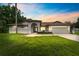 Charming single-story home featuring a well-manicured lawn and attached two car garage at sunset at 3509 Country Creek Ln, Valrico, FL 33596