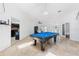 Bright game room featuring a blue felt pool table, tile floors, and views of the entry and kitchen at 3509 Country Creek Ln, Valrico, FL 33596