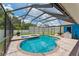 A screened-in pool area featuring a uniquely shaped pool, brick pavers, and spa for luxurious outdoor enjoyment at 3509 Country Creek Ln, Valrico, FL 33596