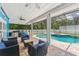 Outdoor pool area with a screened enclosure, patio seating, and lush greenery, ideal for relaxation and entertainment at 3509 Country Creek Ln, Valrico, FL 33596