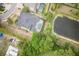 Aerial view of a single Gathering home with a backyard pool, pond, and mature trees surrounding the property at 3603 Arbor Chase Dr, Palm Harbor, FL 34683