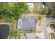 Aerial view of a home with a screened pool, lush landscaping, and a nearby pond at 3603 Arbor Chase Dr, Palm Harbor, FL 34683