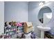 Powder room featuring a pedestal sink, oval mirror, and shoe rack beside a toilet, providing compact convenience at 3603 Arbor Chase Dr, Palm Harbor, FL 34683