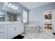 Serene bathroom featuring a soaking tub, double vanity, and walk-in closet access at 3603 Arbor Chase Dr, Palm Harbor, FL 34683