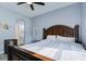 Tranquil bedroom showcasing a dark wooden bed frame and light blue walls, creating a restful ambiance at 3603 Arbor Chase Dr, Palm Harbor, FL 34683