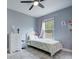 Bright bedroom with tile floor, featuring a window with blinds and view of the backyard at 3603 Arbor Chase Dr, Palm Harbor, FL 34683