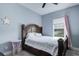 Comfortable bedroom featuring a dark wood bed frame, tile flooring, and a sunlit window for a cozy retreat at 3603 Arbor Chase Dr, Palm Harbor, FL 34683