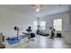 Well-equipped exercise room featuring a treadmill, stationary bike, weight bench, and durable tile flooring at 3603 Arbor Chase Dr, Palm Harbor, FL 34683