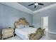Elegant bedroom with a decorative gold bed frame, ceiling fan, and tile floors at 3603 Arbor Chase Dr, Palm Harbor, FL 34683