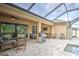 Covered patio with outdoor seating, ceiling fans, and a grill, overlooking a screened pool area at 3603 Arbor Chase Dr, Palm Harbor, FL 34683