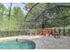 A screened pool with a seating area surrounded by lush landscaping at 3603 Arbor Chase Dr, Palm Harbor, FL 34683