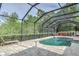 Screened pool surrounded by lush greenery and pavers, with outdoor seating and a lounge chair at 3603 Arbor Chase Dr, Palm Harbor, FL 34683