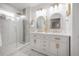 Bright bathroom featuring dual vanity sinks, marble floors, and glass shower enclosure at 3811 N Arlington Ave, Tampa, FL 33603