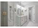 Bright bathroom featuring a double vanity, marble floors, and a glass-enclosed shower with gold hardware at 3811 N Arlington Ave, Tampa, FL 33603