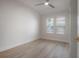 Cozy bedroom with a neutral color palette, ceiling fan, wood floors and bright natural light from two windows at 3811 N Arlington Ave, Tampa, FL 33603