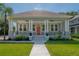 Charming home featuring a welcoming front porch, landscaped yard, and classic architectural details under a clear blue sky at 3811 N Arlington Ave, Tampa, FL 33603