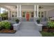 Inviting front porch with gray painted floors, white pillars, ceiling fans, stylish railing, and manicured landscaping at 3811 N Arlington Ave, Tampa, FL 33603