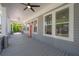 Spacious covered front porch featuring ceiling fans, views of the neighborhood, and a charming coral-colored front door at 3811 N Arlington Ave, Tampa, FL 33603