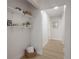 Hallway featuring decor shelving and light wood floors that lead to other rooms at 3811 N Arlington Ave, Tampa, FL 33603