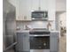 Kitchen showcases stainless steel appliances and gray and white cabinetry at 3811 N Arlington Ave, Tampa, FL 33603
