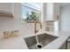 Modern kitchen sink with bright window, patterned backsplash and gold accents at 3811 N Arlington Ave, Tampa, FL 33603