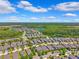Aerial view of a residential area with green lawns, houses and tranquil lakes at 3833 Villamore Ln, Odessa, FL 33556