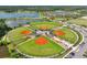 Aerial view of a baseball complex featuring 5 fields with green grass, surrounded by trees and parking at 3833 Villamore Ln, Odessa, FL 33556