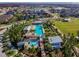 Aerial view of a community pool, playground, and greenspace with a lake and homes in the background at 3833 Villamore Ln, Odessa, FL 33556
