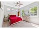 Bright bedroom with large windows, ceiling fan, and red bedding at 3833 Villamore Ln, Odessa, FL 33556