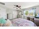 Bright bedroom featuring a computer desk, with views of lush trees outside the windows at 3833 Villamore Ln, Odessa, FL 33556