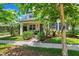 Inviting home exterior with a cozy front porch, lush landscaping, and a well-manicured lawn at 3833 Villamore Ln, Odessa, FL 33556