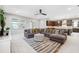 Bright living room adjacent to kitchen with large sectional sofa and decorative area rug at 3833 Villamore Ln, Odessa, FL 33556