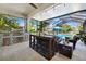 Outdoor kitchen featuring a gas grill, granite countertop, bar seating, and outdoor furniture by the pool at 3833 Villamore Ln, Odessa, FL 33556