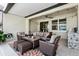 Covered patio features a cozy seating area, ceiling fan, and outdoor grill at 3833 Villamore Ln, Odessa, FL 33556