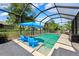 Screened in swimming pool featuring blue umbrellas and -sized pool chairs at 3833 Villamore Ln, Odessa, FL 33556
