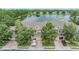 Aerial view of townhomes with a lake view, garages, brick driveways, and mature trees at 3918 Silverlake Way, Wesley Chapel, FL 33544