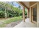 Covered back porch overlooking a green yard with lush landscaping, providing a private outdoor space at 3918 Silverlake Way, Wesley Chapel, FL 33544