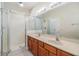 Bathroom with double sinks, large mirror, walk-in shower, and white tile at 3918 Silverlake Way, Wesley Chapel, FL 33544