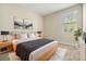 Cozy bedroom with a large window, neutral walls, light wood furniture and minimalist decor at 3918 Silverlake Way, Wesley Chapel, FL 33544