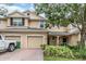 Inviting two-story townhome with attached garages, brick driveway, and lush landscaping at 3918 Silverlake Way, Wesley Chapel, FL 33544