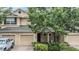 Charming two-story townhome with tan siding, attached garages and mature landscaping at 3918 Silverlake Way, Wesley Chapel, FL 33544