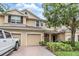 Inviting two-story townhome with attached garages, brick driveway, and lush landscaping at 3918 Silverlake Way, Wesley Chapel, FL 33544